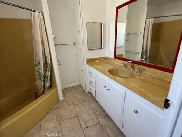 a spacious bathroom with a granite countertop sink a mirror and shower