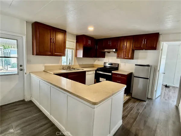 a kitchen with a sink a stove a refrigerator and cabinets