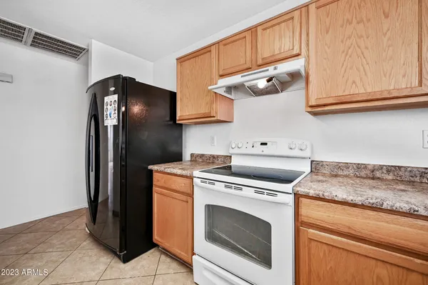 a kitchen with stainless steel appliances granite countertop a refrigerator stove and cabinets