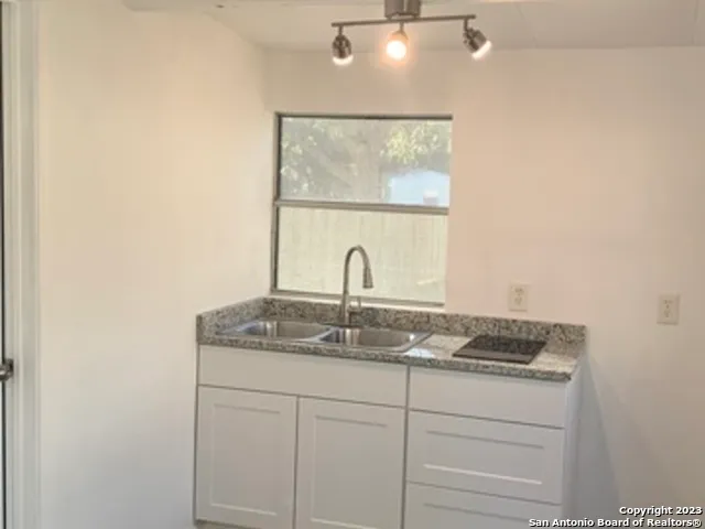 a bathroom with a granite countertop sink and a mirror