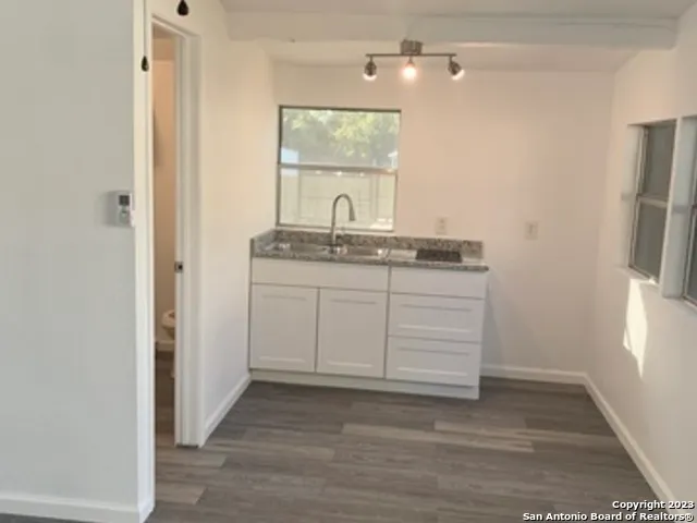 a bathroom with a granite countertop sink a toilet and a mirror