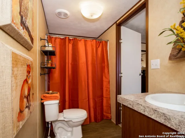 a bathroom with a granite countertop sink toilet and shower
