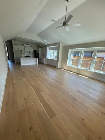 a view of an empty room with a window and a fireplace