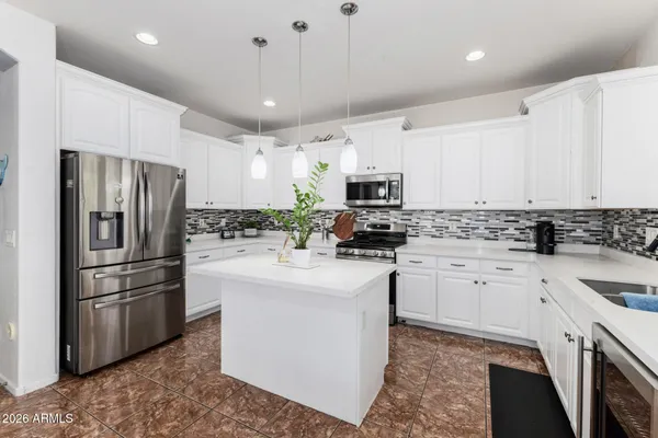 a kitchen with kitchen island a white cabinets and refrigerator