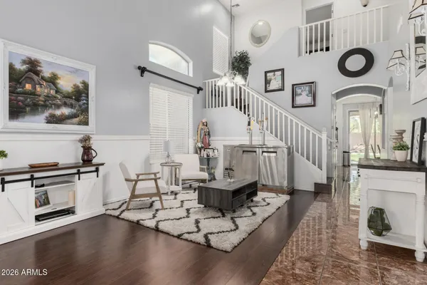 a living room with couches a fireplace and kitchen view with wooden floor