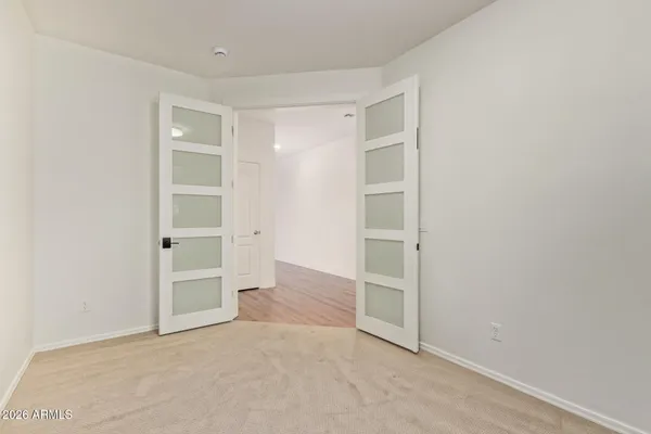an empty room with closet and windows