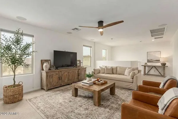 a view of a big room with a ceiling fan and windows