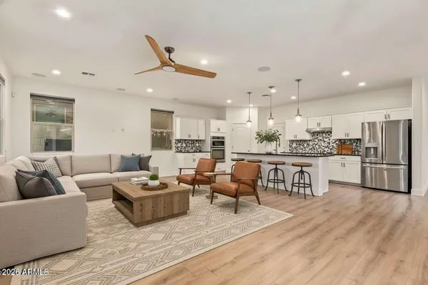 a living room with stainless steel appliances kitchen island granite countertop a couch and a view of kitchen