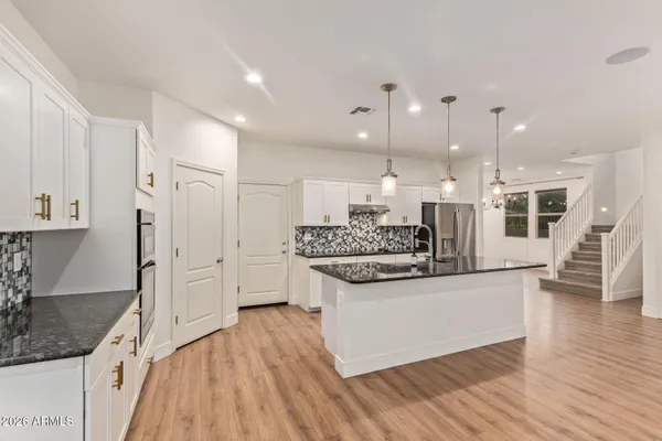 a kitchen with stainless steel appliances kitchen island granite countertop a stove and a refrigerator