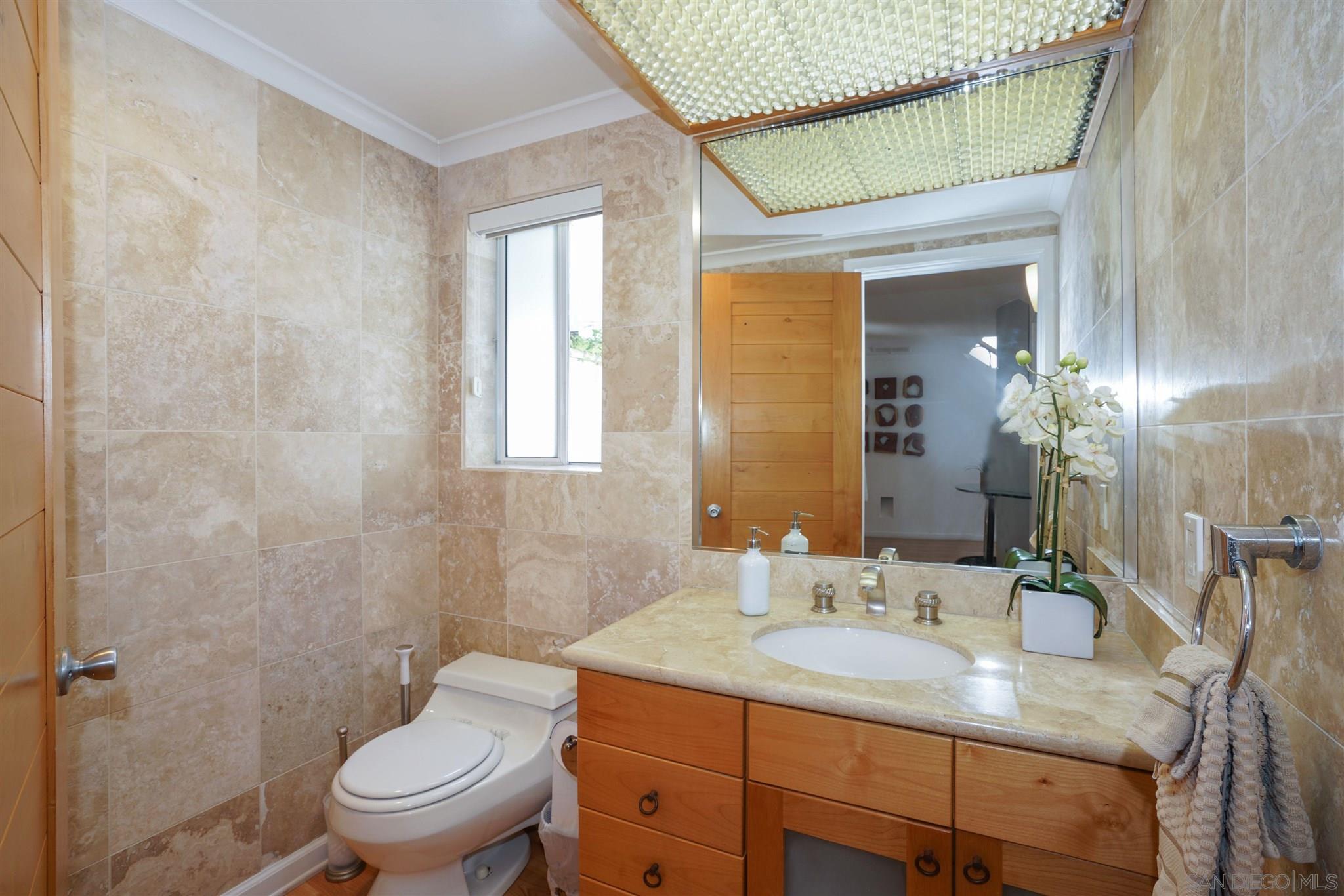 57 Blue Anchor Cay Road Coronado, CA 92118 - Photo 31 of 37 a bathroom with a granite countertop sink a toilet and a mirror