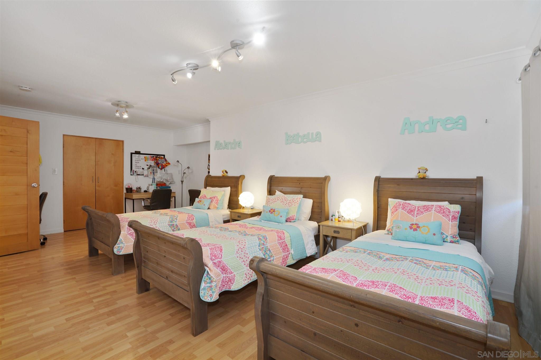 57 Blue Anchor Cay Road Coronado, CA 92118 - Photo 33 of 37 a bedroom with two beds and a chandelier