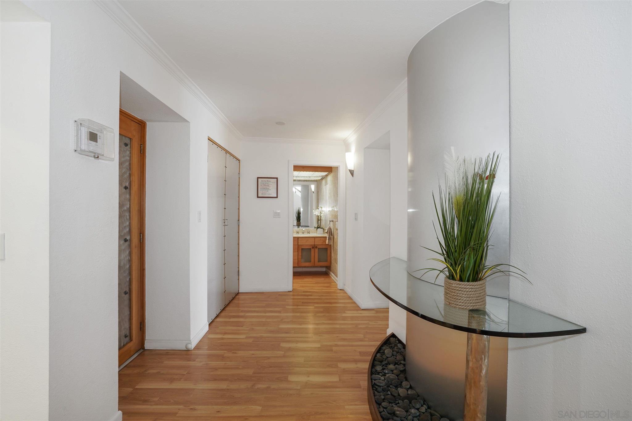 57 Blue Anchor Cay Road Coronado, CA 92118 - Photo 8 of 37 a view of a hallway with wooden floor and a potted plant