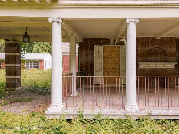 a view of a white house with a yard and potted plants