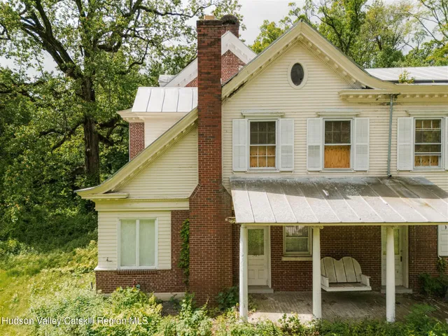 a front view of a house with a garden and plants