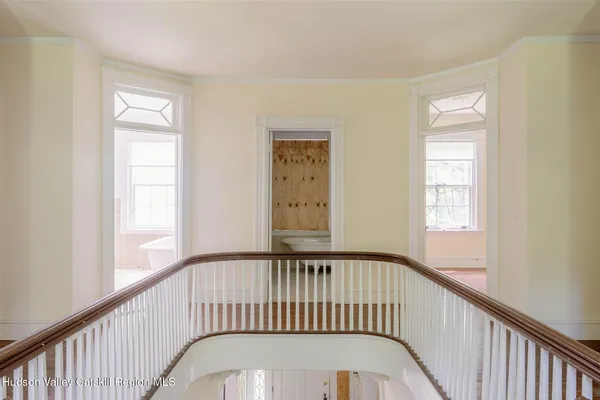 a view of a hallway view with wooden floor and a bathroom
