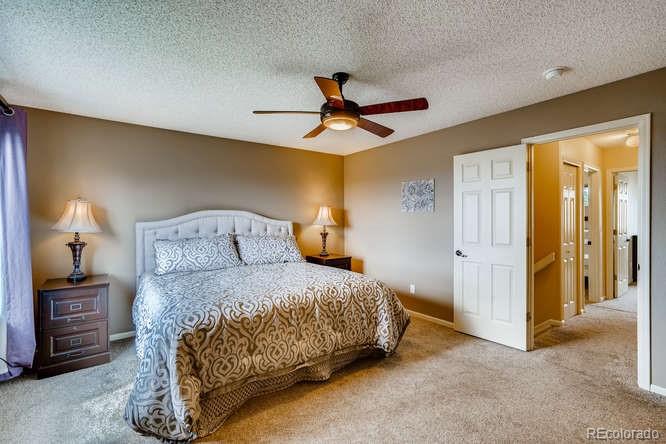 11181 Rodeo Circle Parker, CO 80138 - Photo 14 of 26 a bedroom with a bed and a chandelier