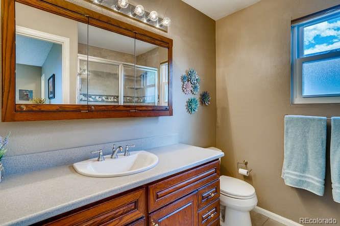 11181 Rodeo Circle Parker, CO 80138 - Photo 18 of 26 a bathroom with a toilet a sink and mirror