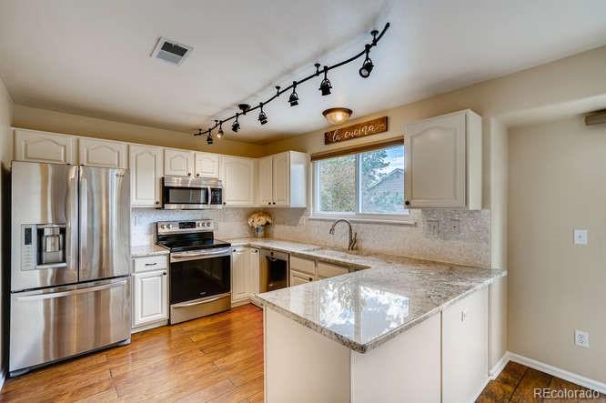 11181 Rodeo Circle Parker, CO 80138 - Photo 5 of 26 a kitchen with stainless steel appliances granite countertop a sink stove and refrigerator