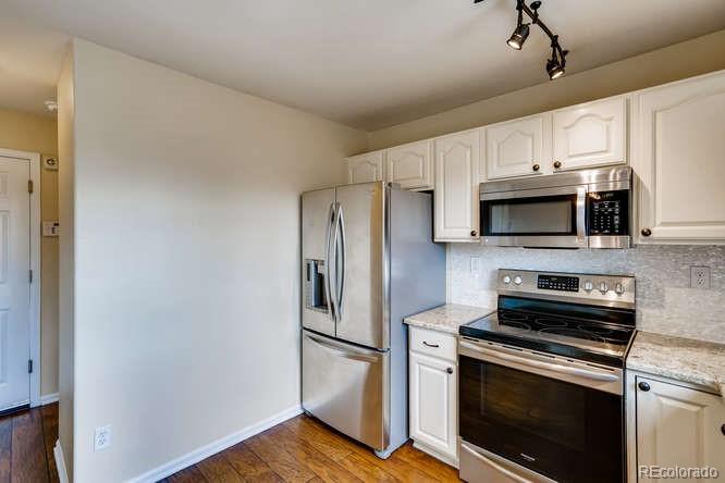 11181 Rodeo Circle Parker, CO 80138 - Photo 6 of 26 a kitchen with stainless steel appliances a stove a microwave and a hard wood floor