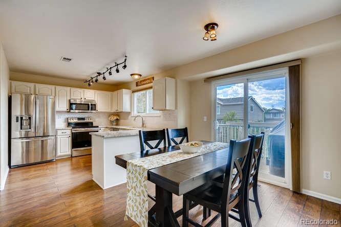 11181 Rodeo Circle Parker, CO 80138 - Photo 9 of 26 a kitchen with a table chairs refrigerator and cabinets