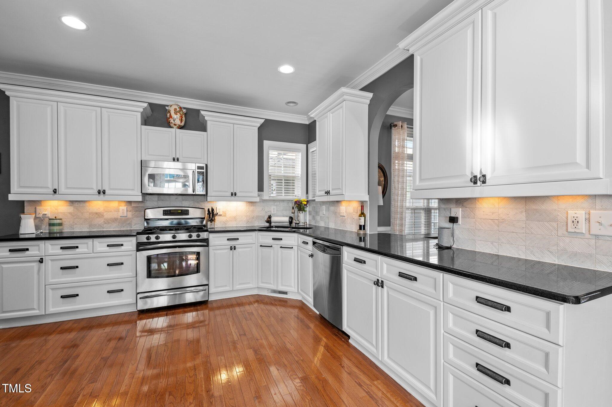 1209 Harp Street Raleigh, NC 27604 - Photo 15 of 39 a kitchen with granite countertop white cabinets and white appliances