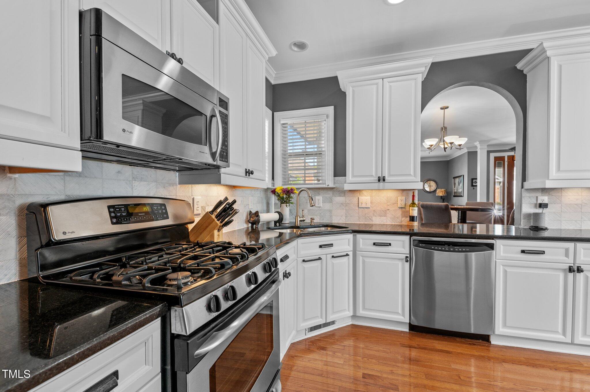 1209 Harp Street Raleigh, NC 27604 - Photo 17 of 39 a kitchen with stainless steel appliances a sink a stove and cabinets