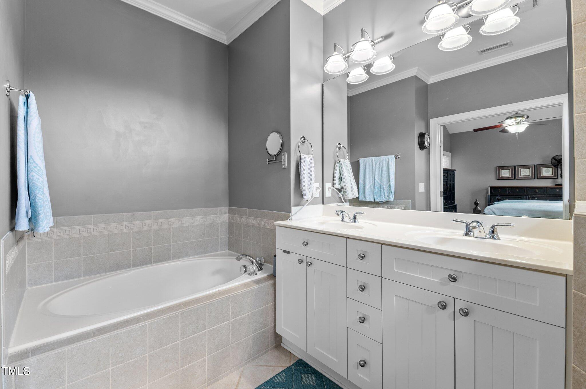1209 Harp Street Raleigh, NC 27604 - Photo 32 of 39 a bathroom with a tub a double vanity sink and a mirror