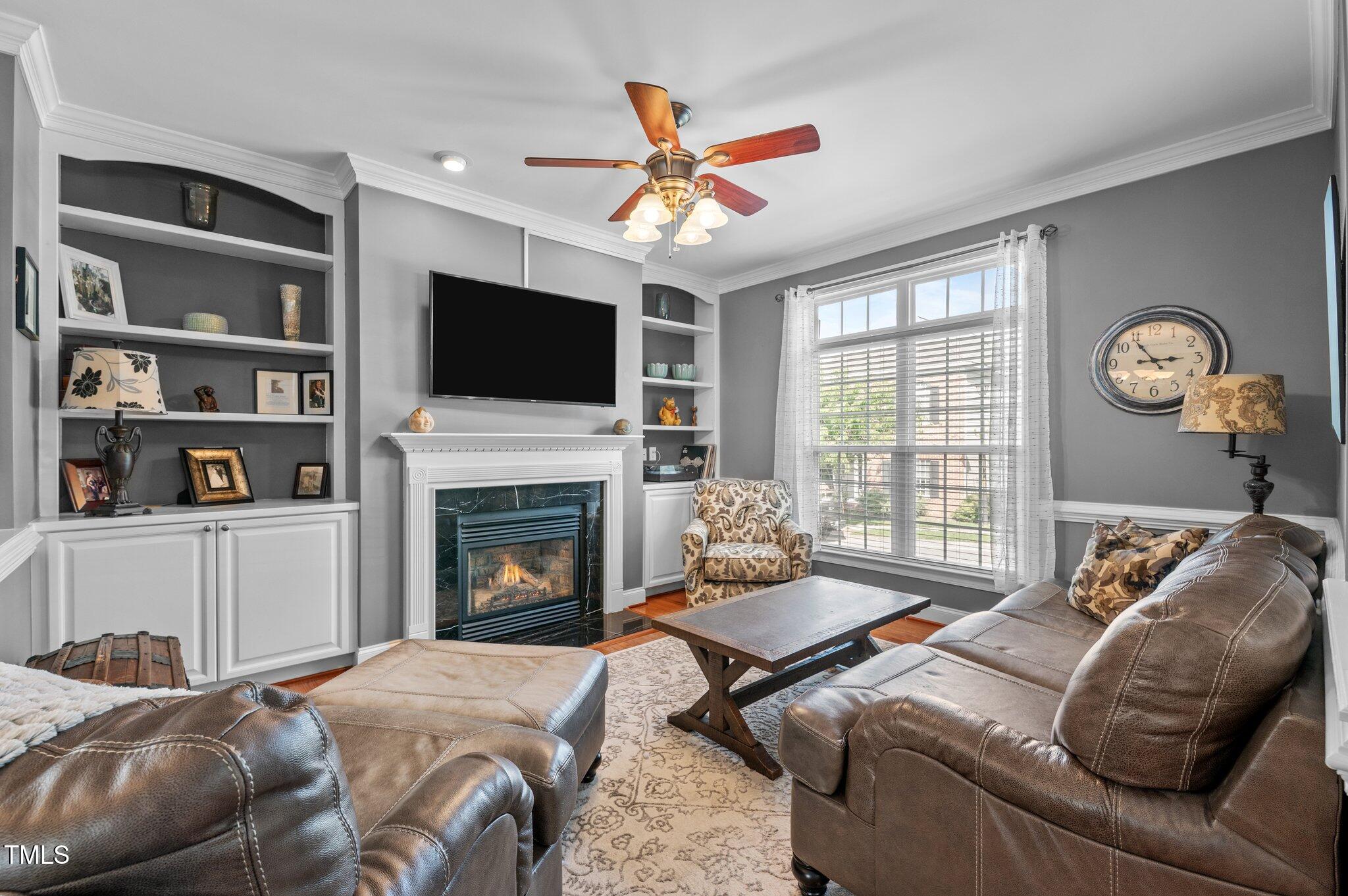 1209 Harp Street Raleigh, NC 27604 - Photo 9 of 39 a living room with furniture a flat screen tv and a fireplace