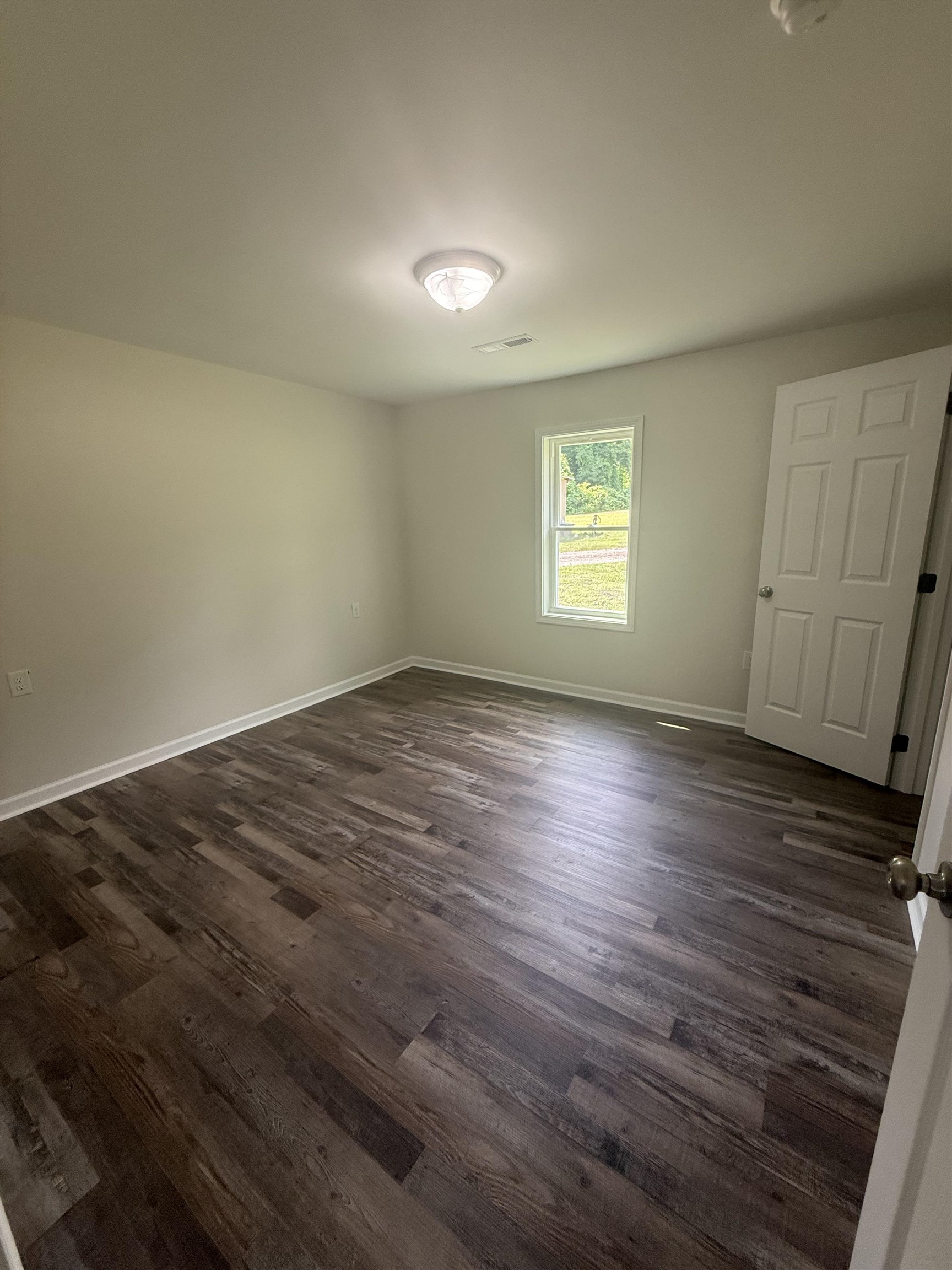 170 Leapwood Road Enville, TN 38332 - Photo 9 of 33 Spacious room featuring wood-finish flooring, light-toned walls, and a ceiling-mounted light fixture