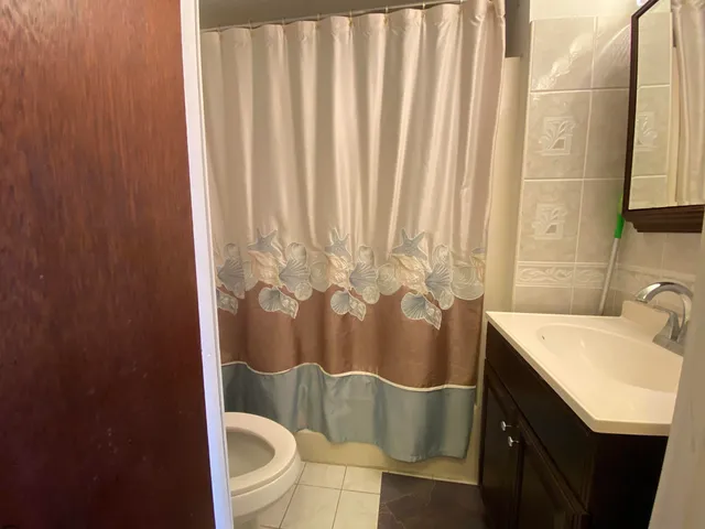 a bathroom with a sink a toilet and shower curtain