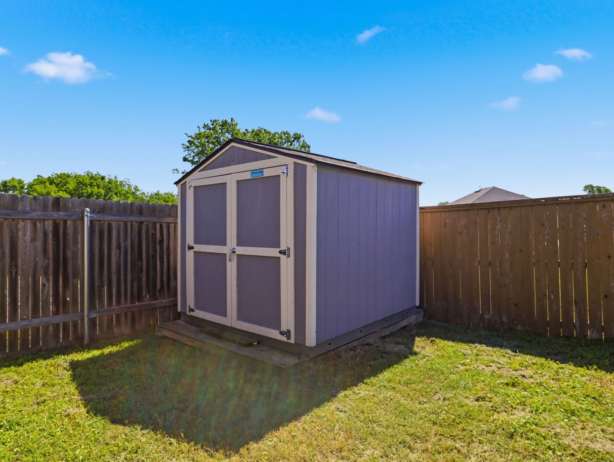 640 Landon Samuel Loop Pflugerville, TX 78660 - Photo 29 of 33 Backyard featuring a shed with a gabled roof, double doors, and a wood foundation