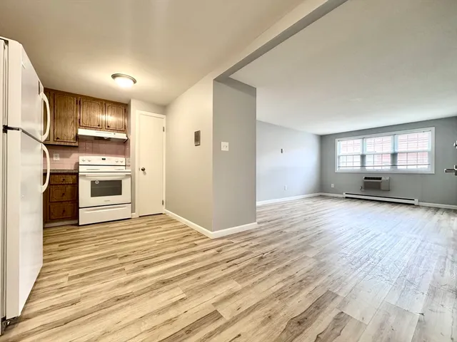 a view of empty room with wooden floor and fireplace