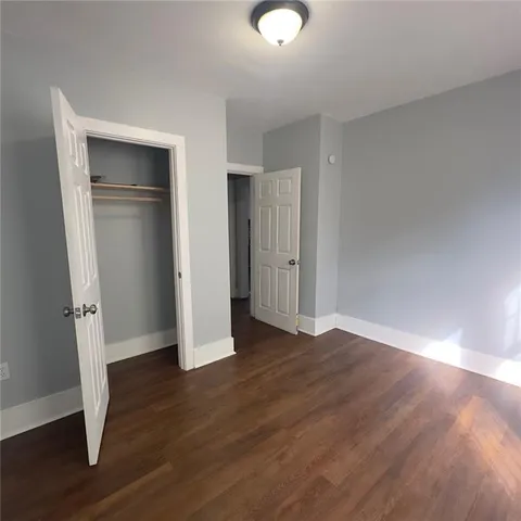 an empty room with wooden floor and closet