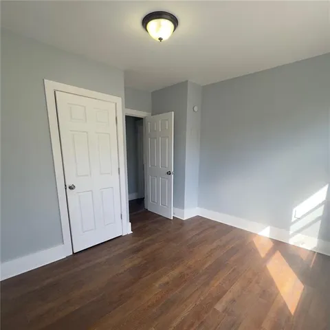 an empty room with wooden floor and closet