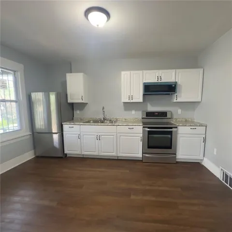 a kitchen with stainless steel appliances a stove a sink and a refrigerator