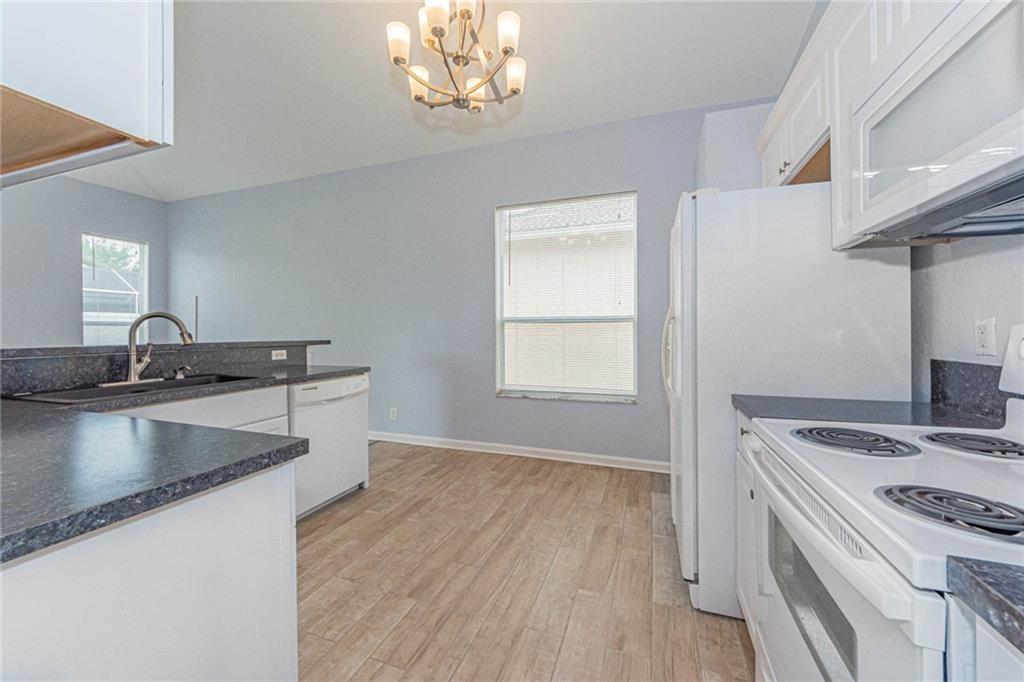 5544 Spanish River Road Fort Pierce, FL 34951 - Photo 11 of 35 a kitchen that has a sink a stove and wooden floor