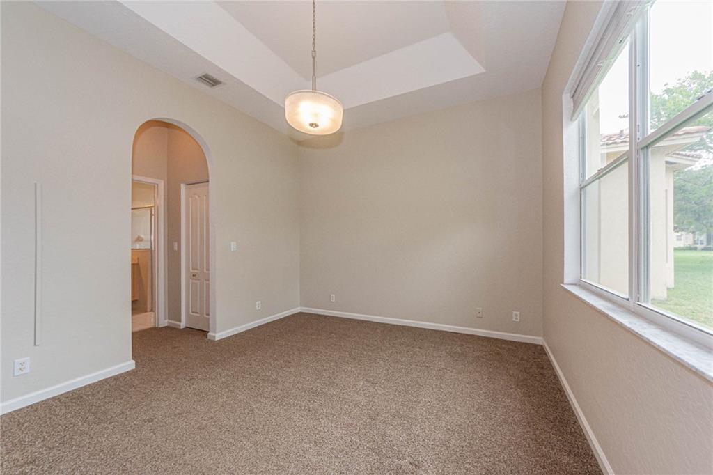 5544 Spanish River Road Fort Pierce, FL 34951 - Photo 16 of 35 an empty room with windows and chandelier