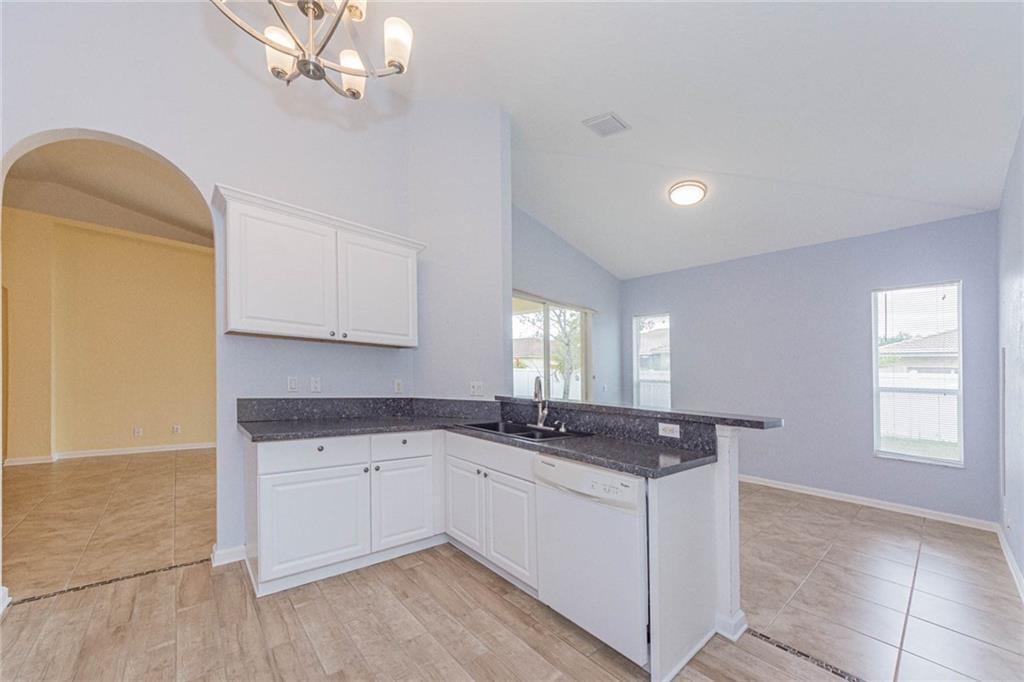 5544 Spanish River Road Fort Pierce, FL 34951 - Photo 9 of 35 a kitchen with granite countertop white cabinets and white appliances