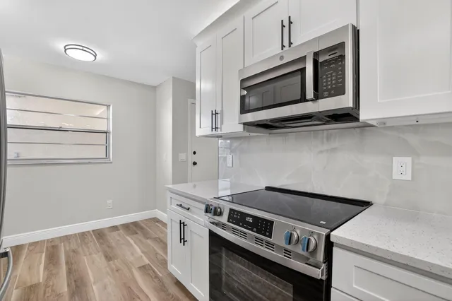 a bathroom with a toilet a sink a mirror a shower a vanity and window