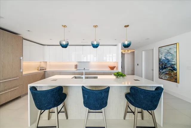 a large kitchen with stainless steel appliances lots of counter space and a sink