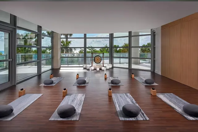 a living room with stainless steel appliances furniture a rug and a large window