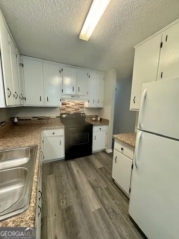 a kitchen with a sink a refrigerator a washer and dryer