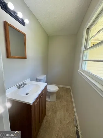 a bathroom with a sink mirror and toilet