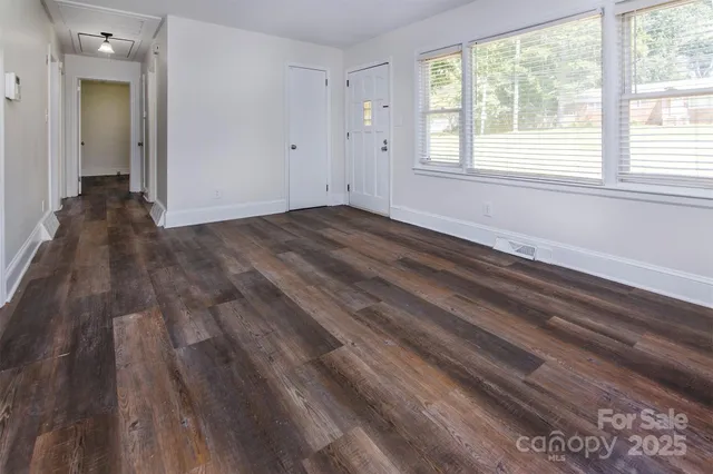 a view of empty room with wooden floor