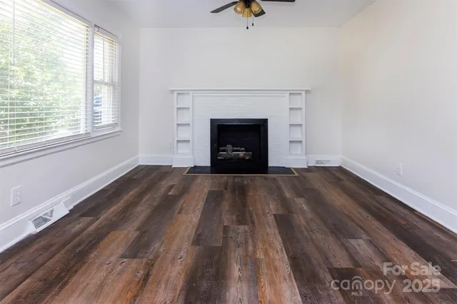 wooden floor fireplace and window in an empty room