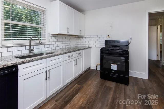 a kitchen with granite countertop a stove and a sink
