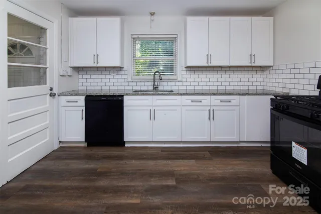 a kitchen with granite countertop wooden cabinets and a stove