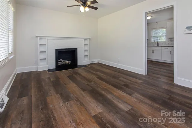 a view of empty room with wooden floor and fireplace