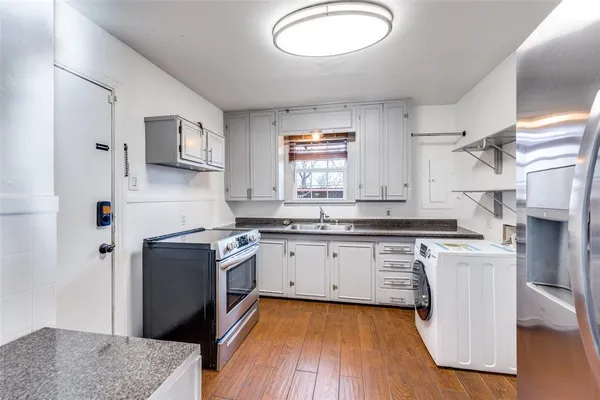 a kitchen with stainless steel appliances granite countertop a stove a sink and a refrigerator