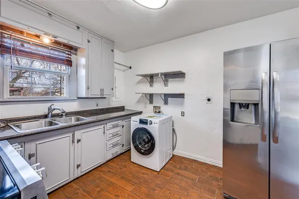 a kitchen with stainless steel appliances granite countertop a sink and a refrigerator